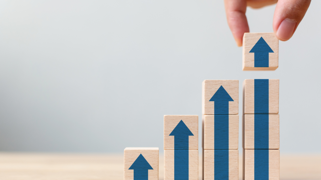 Wooden blocks with arrows pointing upwards, symbolising growth and the profit-driven impact of upskilling through public speaking training.